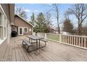 Large wooden deck featuring a picnic table, with a view of trees and a glimpse of the lake beyond at 5111 S Poplar Dr, Columbus, IN 47201