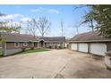 Expansive property with a long driveway leading to a three-car garage, surrounded by trees and greenery at 5111 S Poplar Dr, Columbus, IN 47201