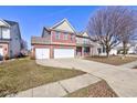 Charming two-story home with a brick facade, three-car garage, and well-kept lawn at 5402 Basin Park Dr, Indianapolis, IN 46239
