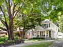 Traditional home featuring a well-manicured lawn and mature trees providing shade and curb appeal at 5426 Broadway St, Indianapolis, IN 46220