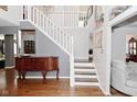 Staircase with white railings, complemented by a stylish foyer and hardwood floors at 5855 Dapple Trce, Indianapolis, IN 46228