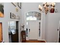 Bright foyer with a chandelier, hardwood flooring, and a decorative transom window at 5855 Dapple Trce, Indianapolis, IN 46228