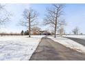 Long driveway leading up to a beautiful brick home with mature trees and a snowy yard at 6024 N County Road 50 W, Lizton, IN 46149