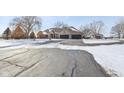 Exterior view of brick home with three-car garage, mature trees, and a snowy driveway at 6024 N County Road 50 W, Lizton, IN 46149