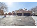 Exterior view of brick home with three-car garage, bare trees, and a driveway with snow at 6024 N County Road 50 W, Lizton, IN 46149