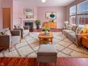 Cozy living room with pink walls, a fireplace, plush seating, and an elegant rug at 6830 Shooting Star Dr, Whitestown, IN 46075