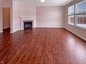 Bright living room with beautiful wood floors, a fireplace, and large windows for ample natural light at 6830 Shooting Star Dr, Whitestown, IN 46075