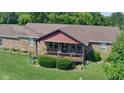 Charming brick home with a covered porch and beautiful landscaping surrounded by a lush green lawn at 7152 Old Morgantown Rd, Martinsville, IN 46151