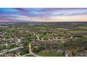 Aerial view of a lovely neighborhood with mature trees, a pond, and lush green spaces at 7357 Windridge Way, Brownsburg, IN 46112