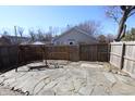 Serene backyard featuring a stone patio, wooden swing, and secure fencing, creating a perfect outdoor retreat at 7438 Melanie Ln # 13, Indianapolis, IN 46217