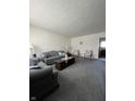 Living room with blue carpet, couch, coffee table and sitting chairs at 7632 S Sherman Dr, Indianapolis, IN 46237