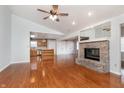 Inviting living room featuring laminate flooring, a brick fireplace, and a ceiling fan at 8417 Southern Springs Way, Indianapolis, IN 46237