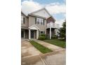 Attractive townhome featuring tan siding, a private balcony, a well-maintained lawn, and a convenient driveway at 12145 Bubbling Brook Dr # 600, Fishers, IN 46038