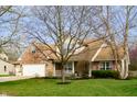 Traditional two-story home with brick and siding, a well-kept lawn, and mature landscaping at 12512 Geist Cove Dr, Indianapolis, IN 46236