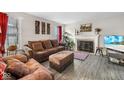 Cozy living room with a fireplace, comfortable brown furniture, and plenty of natural light at 13812 Barnett Pl, Fishers, IN 46038