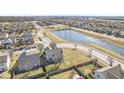 Expansive aerial view of a home with a fenced backyard, situated near a serene lake and a well-planned community at 15101 Proud Truth Dr, Noblesville, IN 46060