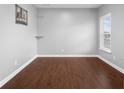 Empty room featuring hardwood floors, ample natural light, and neutral paint at 2016 Woodland Parks Dr, Columbus, IN 47201