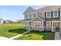 Charming two-story townhome boasts a manicured lawn, a covered porch, and a welcoming walkway, perfect for suburban living at 2165 Mildred Rd, Westfield, IN 46074