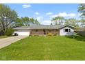 Cozy single story home boasting a well-kept lawn, a wooden porch and an attached garage at 2230 Mindy Ct, Anderson, IN 46017