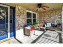 Relaxing covered front porch with stone accents, a ceiling fan, and comfortable seating area, creating a cozy outdoor space at 265 Goodnight Rd, Martinsville, IN 46151