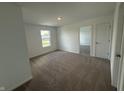 Bright bedroom with plush carpet, a window with pleasant views, and an open doorway leading to another room at 3328 Stafford St, Sheridan, IN 46069