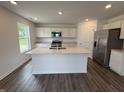 Modern kitchen featuring stainless steel appliances, sleek white cabinets, and a large island with a sink at 3328 Stafford St, Sheridan, IN 46069