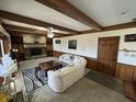 Inviting living room featuring wood-beamed ceiling, stone fireplace, and neutral decor at 3515 Beechwood Ln, Anderson, IN 46011