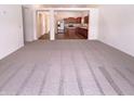 Spacious living room with neutral carpet and ample natural light, flowing into the kitchen at 4943 Dunlin Dr, Indianapolis, IN 46235
