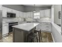 Modern kitchen with white cabinets, stainless steel appliances, and a center island with stool seating at 5503 Thompson Park Blvd, Indianapolis, IN 46237