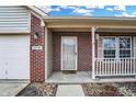 Inviting front porch features brick accents, a cozy seating area, and a charming entrance at 5772 Jamestown Square Ln, Indianapolis, IN 46234