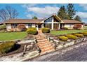 Landscaped front yard with brick steps and retaining wall leading up to the ranch-style home at 6114 Brokenhurst Rd, Indianapolis, IN 46220