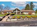 Landscaped front yard with brick steps and retaining wall leading up to the ranch-style home at 6114 Brokenhurst Rd, Indianapolis, IN 46220