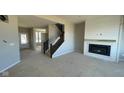 Inviting living room with a modern fireplace, staircase, and ample space for entertaining at 6272 Willow Branch Way, Plainfield, IN 46168