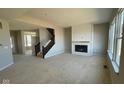 Bright living room featuring a fireplace with shiplap, staircase, and large windows at 6272 Willow Branch Way, Plainfield, IN 46168