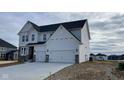 New construction home with a two-car garage, stone accents and landscaping potential in a developing community at 6323 Willow Branch Way, Plainfield, IN 46168