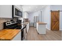Modern kitchen featuring stainless steel appliances, white cabinets, and attractive butcher block countertops at 721 E Morris St, Indianapolis, IN 46203