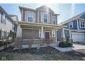 Two-story home featuring a covered front porch that provides a shady spot, well-kept landscaping adding to the appeal at 7228 Broadacre Ct, Carmel, IN 46033