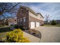 Spacious three-car garage and driveway, complemented by well-maintained landscaping at 7239 Bellini Ln, Indianapolis, IN 46259