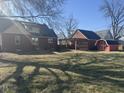 Large backyard features a wooden pergola, detached garage, and a charming red shed, perfect for outdoor projects at 730 E Main St, Plainfield, IN 46168