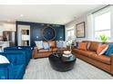 Well-lit living room with plush seating, a large decorative clock, and views to the backyard at 7572 Bluegill Dr, Noblesville, IN 46062