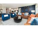 Inviting living room features a leather sofa, blue chairs, modern decor, and wood-look floors at 7572 Bluegill Dr, Noblesville, IN 46062
