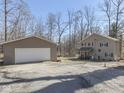 View of the home with a detached two car garage and a spacious gravel driveway at 8460 S Green Dr, Nineveh, IN 46164