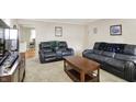 Comfortable living room with carpet, leather sofas, and view into the kitchen at 8715 Legion Ln, Indianapolis, IN 46231