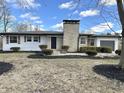Well-maintained single-story home featuring a prominent stone chimney, neutral siding, and clean landscaping at 8795 Carrollton Ave, Indianapolis, IN 46240