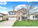 Well-maintained two-story home featuring brick and siding, a two-car garage, and a lovely front yard at 9243 Crossing Dr, Fishers, IN 46037