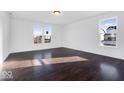Open living room with hardwood floors and plenty of sunlight from large windows at 9307 Harlow Way, Plainfield, IN 46168