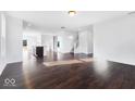 Spacious living room showcasing hardwood floors, a staircase, and an open layout at 9307 Harlow Way, Plainfield, IN 46168