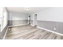 Bright living room featuring wood-look flooring, gray wainscoting, and neutral wall paint at 9923 N 125 W, Fortville, IN 46040