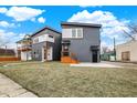 Two-story home showcases a contemporary design with gray siding, a welcoming entrance, and a green front lawn at 1024 Calvary St, Indianapolis, IN 46203