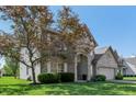 Beautiful brick home with an attached two-car garage and a lovely, green lawn at 10576 Greenway Dr, Fishers, IN 46037